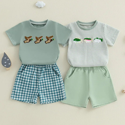 Baby boy summer outfit featuring short-sleeve embroidered fish/duck T-shirt and plaid or solid shorts for toddlers