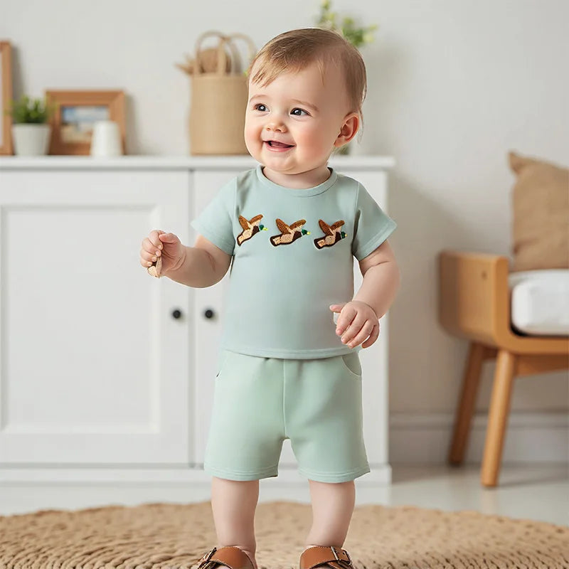 Baby boy summer outfit featuring short-sleeve embroidered fish/duck T-shirt and plaid or solid shorts for toddlers